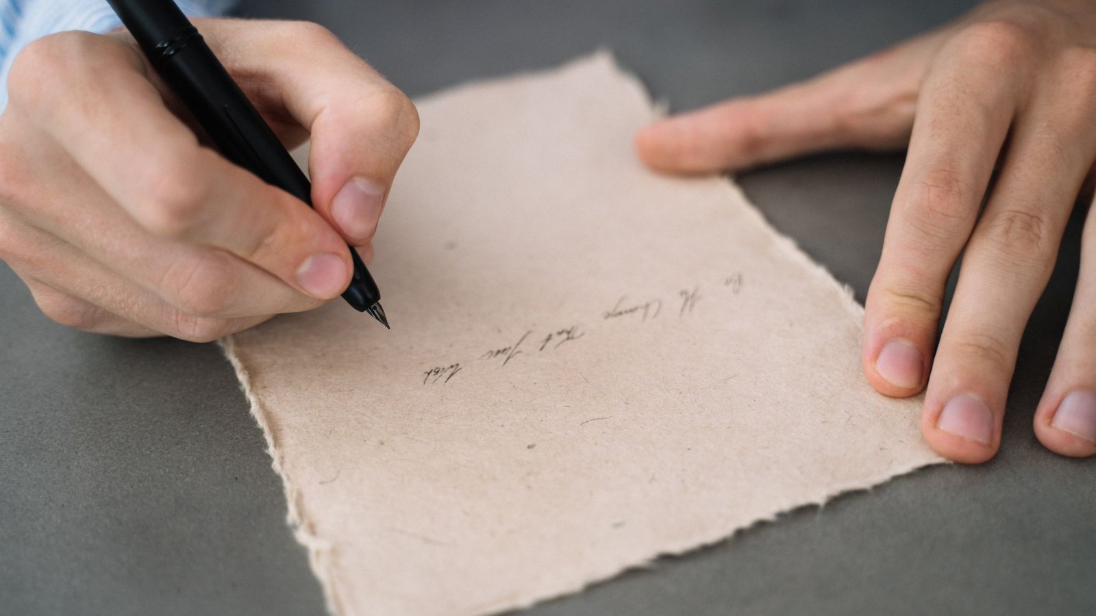 Kéz, ahogy tollal kézzel írt levelet ír papírra