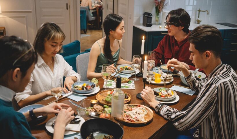 Barátok koccintanak és beszélgetnek egy nyugodt közös vacsorán